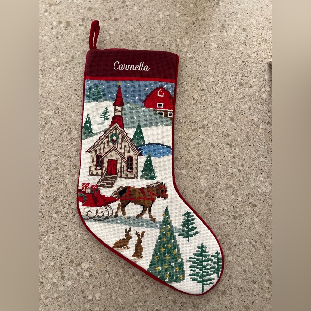 Needlepoint stocking with name “Carmella” embroidered on it